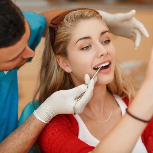 Woman looking at smile after dental treatment