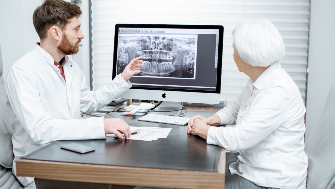 Dentist and dental patient discussing all on four dental implants