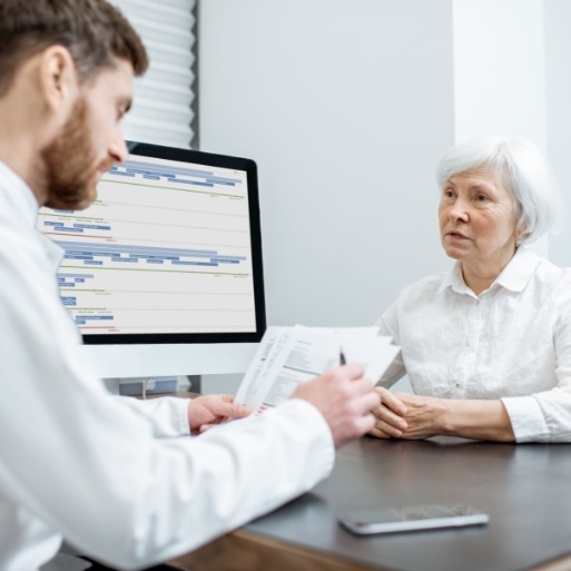 Dentist and dental patient discussing all on four dental implant tooth replacement