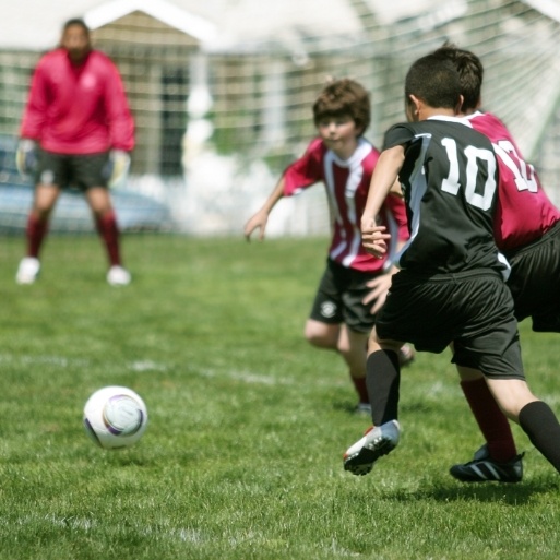 Kids playing soccer with athletic mouthguards for protection
