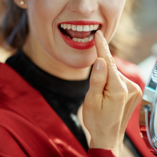 Woman pointing to smile after cosmetic dental bonding