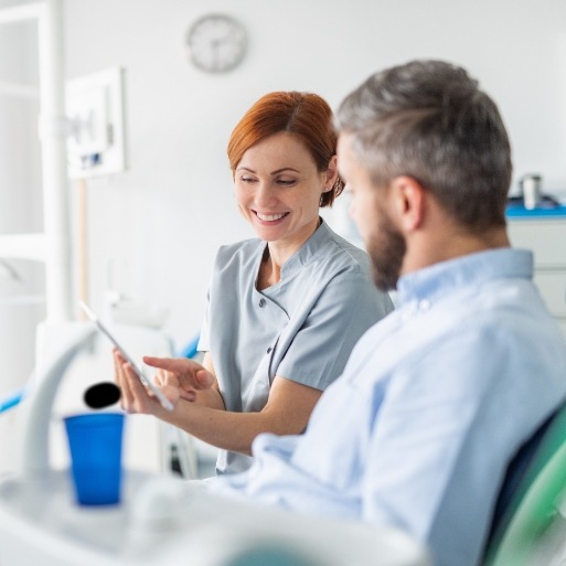 Dental team member talking to patient during dental checkup and teeth cleaning visit