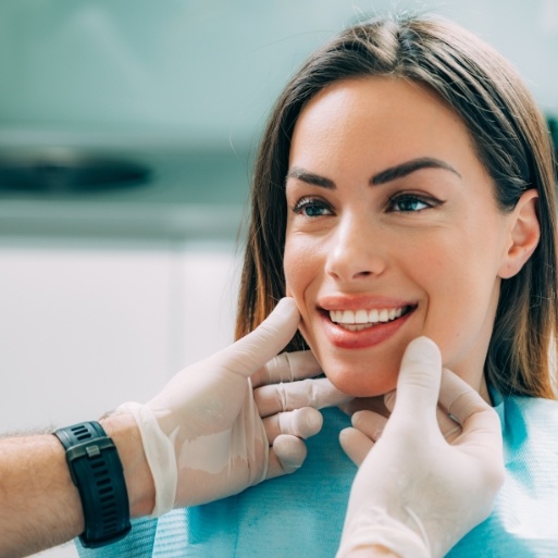 Dentist examining woman's smile during preventive dental care
