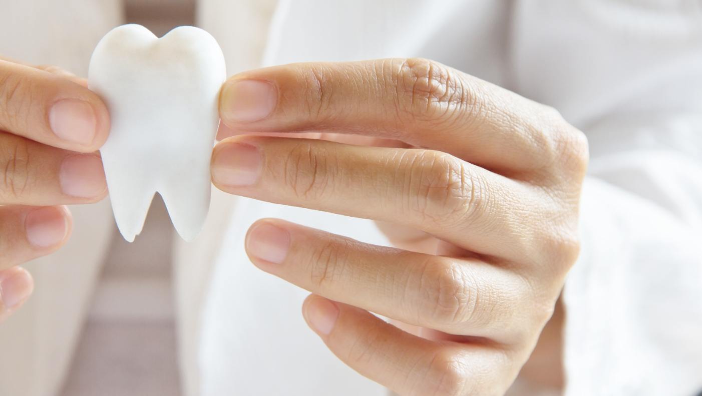 Dentist using model tooth to explain tooth colored filling process