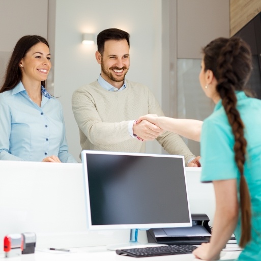 Dental patients greeting dental team member after replacing missing teeth