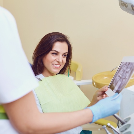 Dentist and dental patient discussing dental implant tooth replacement