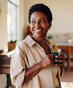 Smiling woman enjoying coffee at home