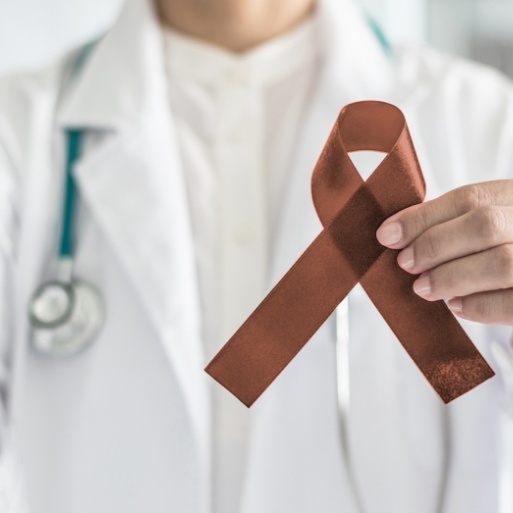 Dentist holding oral cancer screening awareness ribbon