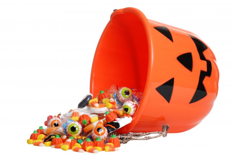 A bucket of candy spilling onto the ground.