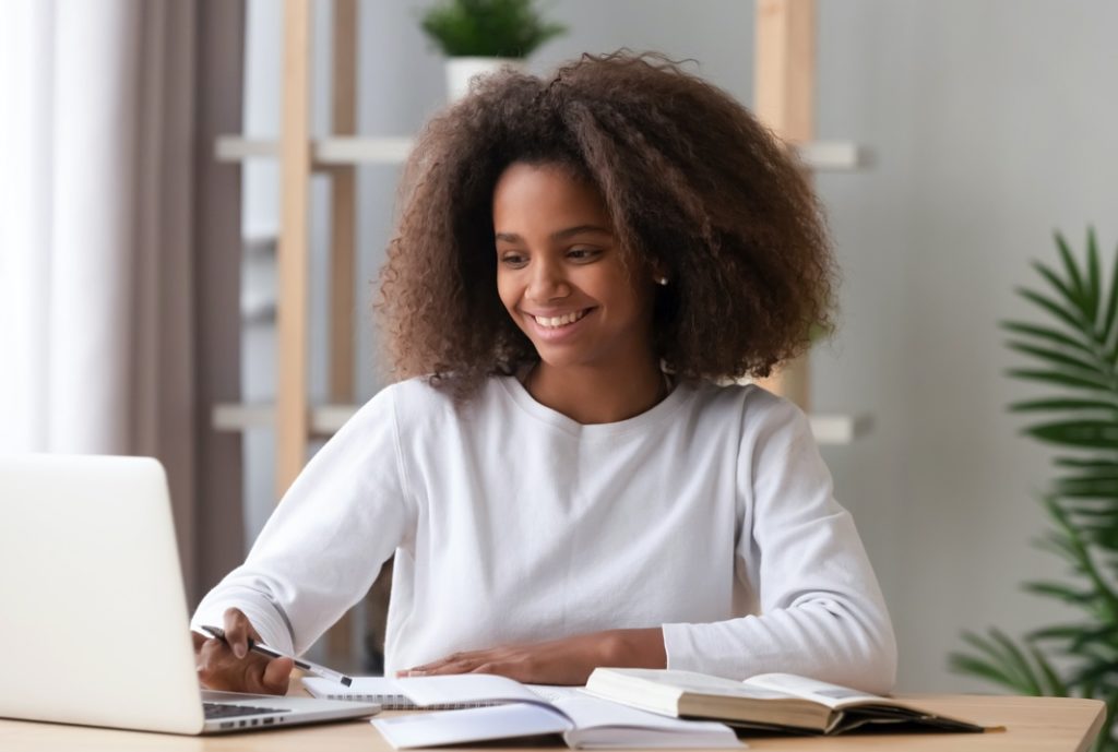 Girl smiling while doing homework