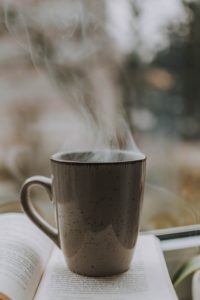 Steaming coffee cup on book