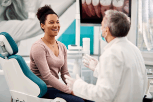 Woman smiling during a teeth whitening consultation with her dentist
